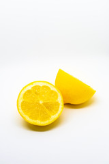 A vibrant yellow sliced lemon isolated on white background