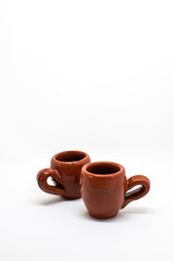 Two tiny iconic brown hot chocolate mugs isolated on a white background