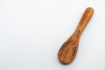 Small dark wooden spoon on a white isolated background with blank space for text
