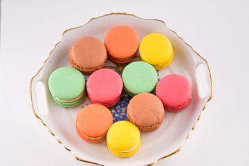 Multi-coloured macarons on a porcelain plate