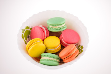 Multi-coloured macarons on a porcelain plate
