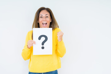 Middle age woman thinking and holding paper with question mark symbol over isolated background screaming proud and celebrating victory and success very excited, cheering emotion