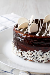 Homemade chocolate cherry cake on white plate, side view. Close-up.