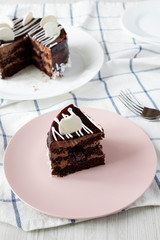 Homemade chocolate cherry cake on pink plate, side view. Close-up.