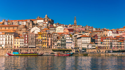 Fototapeta na wymiar Colorful houses of Porto Ribeira, traditional facades, old multi-colored houses with red roof tiles on the embankment in the city of Porto, Portugal