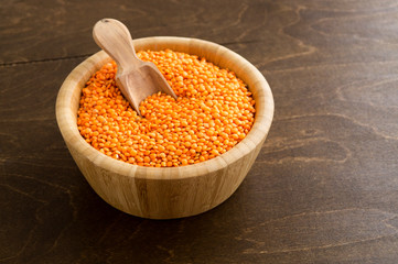 Red dry lentils in a bamboo bowl.