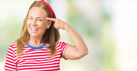 Beautiful middle age woman wearing casual stripes t-shirt over isolated background Smiling pointing to head with one finger, great idea or thought, good memory