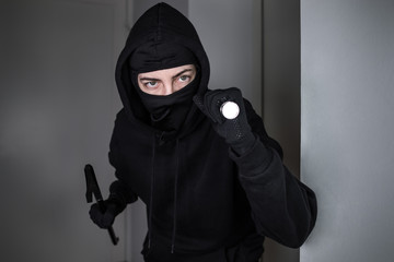 Maskierter Einbrecher dringt mit Taschenlampe und Brecheisen in Wohnung ein 