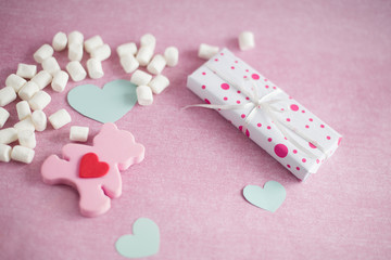 gift box tied with a ribbon lies on a pink background, box, pink bear, marshmallow, hearts lie on a pink background, background on Valentine's day  (horizontally)