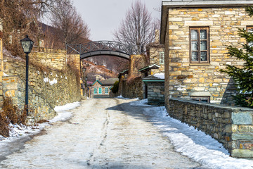 Fototapeta premium View of traditional stone buildings and streets with snow at the famous village of Nymfaio near Florina, Greece. 