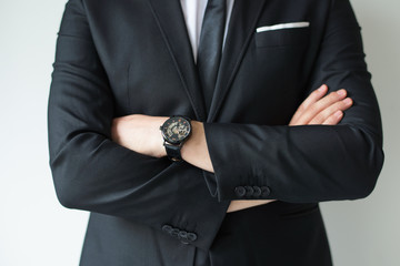 Confident businessman posing with arms crossed. Cropped portrait of business leader in suit with...