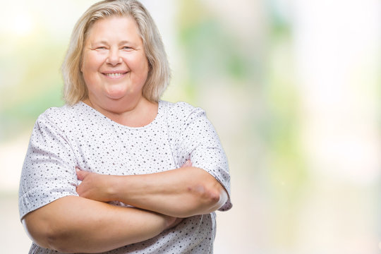 Senior plus size caucasian woman over isolated background happy face smiling with crossed arms looking at the camera. Positive person.