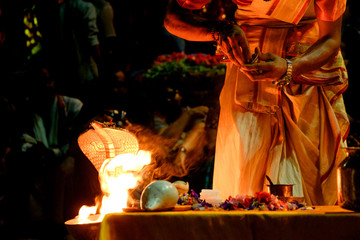 close up of young hindu priest performing daily ritual ganga aarti ceremony with fire and symbolic...