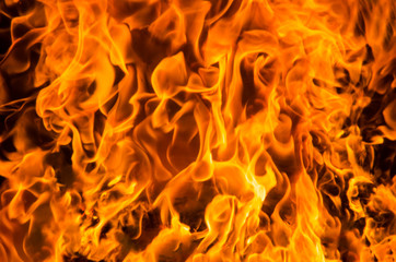 Orange flame of fire inside fireplace behind glass