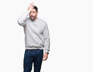 Fototapeta premium Young handsome man wearing sweatshirt over isolated background surprised with hand on head for mistake, remember error. Forgot, bad memory concept.