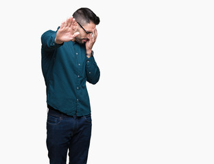 Young handsome business man wearing glasses over isolated background covering eyes with hands and doing stop gesture with sad and fear expression. Embarrassed and negative concept.