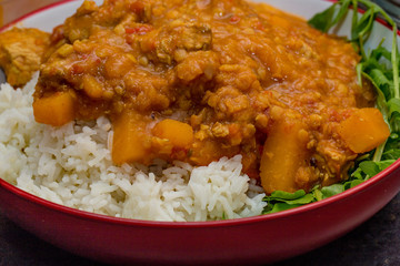 Turky Dhansak curry on a bed of basmati rice with a side of rocket