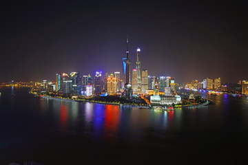 Obraz na płótnie Canvas A night view of the modern Pudong skyline across the Bund in Shanghai, China
