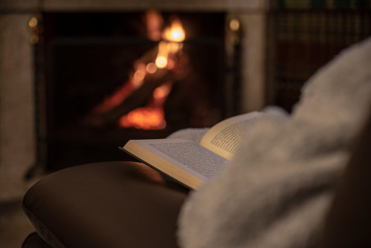 Woman resting with book near fireplace