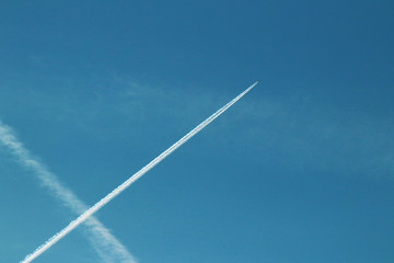Chemtrails and airplane flying in the blue sky