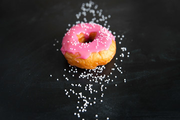 Obraz na płótnie Canvas Pink donut on black background