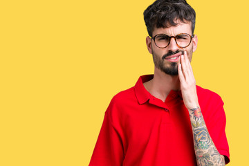 Young handsome man wearing glasses over isolated background touching mouth with hand with painful expression because of toothache or dental illness on teeth. Dentist concept.