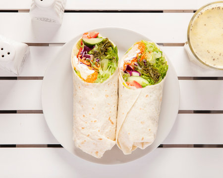 Vegan wrap, top down view -  Beautifully arranged and surved on a white wooden table