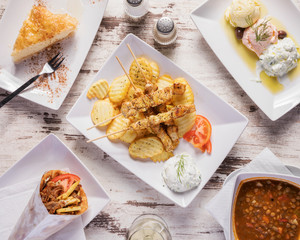 Greek food, natural top down shot - Delicious mediterranean dishes arranged beautifully on a white table for group dinner in a tavern