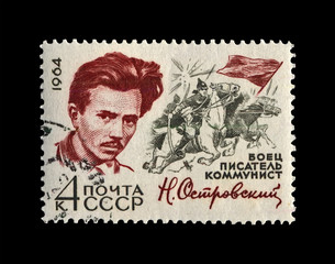 Ostrovsky Nikolai (1904-1936), famous russian writer, commissar, circa 1971. Best known for his novel How the Steel Was Tempered. vintage post stamp of USSR isolated on black background.