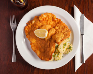 Austrian Food, Schnitzel - Top shot of delicious austrian meal beautifully arranged on a wooden table