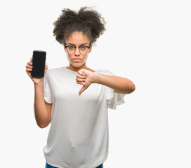 Young beautiful afro american showing smartphone screen over isolated background with angry face, negative sign showing dislike with thumbs down, rejection concept