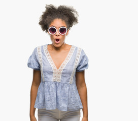 Young afro american woman wearing glasses over isolated background afraid and shocked with surprise expression, fear and excited face.