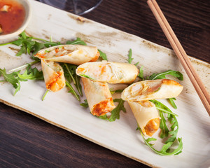 Top down view of fresh spring rolls, beautifully arranged on a wooden plate