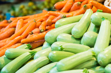 Fresh cropped green zucchini and carrots on the market. Vegetable background (selective focus)