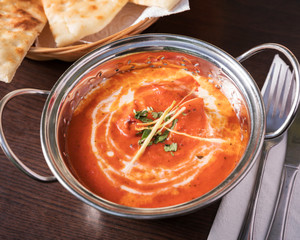 Indian food, Butter Chicken - Top down view of delicious oriental dish, beautifully arranged on a dark wooden table