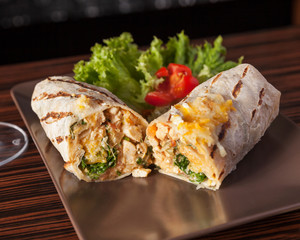 Mexican food, Burrito - A delicious burrito beautifully served on a dark wooden table