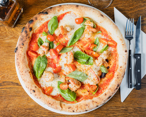 Authentic Italian Pizza, Gambaretti - Delicious prawn Pizza, beautifully arranged on a wooden table