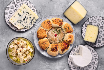 take from above cheesecake and other pieces of cheese on gray marbled background