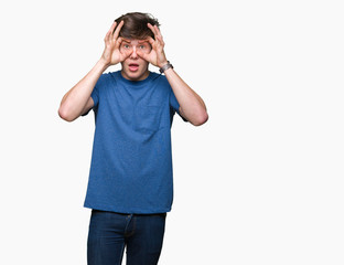 Young handsome man wearing blue t-shirt over isolated background Trying to open eyes with fingers, sleepy and tired for morning fatigue