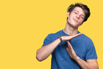 Young handsome man wearing blue t-shirt over isolated background Doing time out gesture with hands, frustrated and serious face