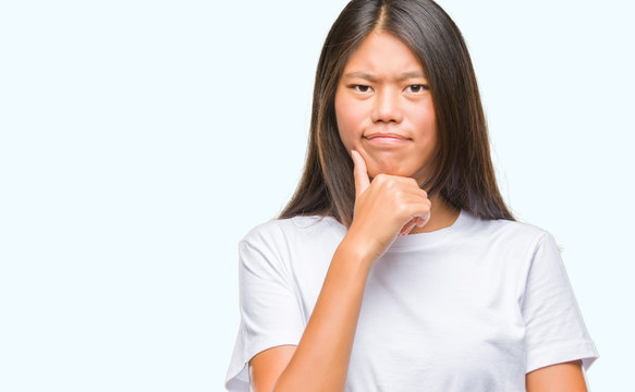 Young asian woman over isolated background looking confident at the camera with smile with crossed arms and hand raised on chin. Thinking positive.
