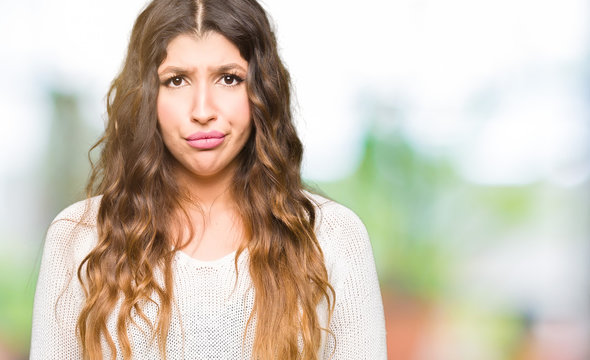 Young beautiful woman wearing white sweater depressed and worry for distress, crying angry and afraid. Sad expression.