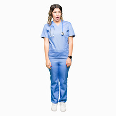 Fototapeta premium Young adult doctor woman wearing medical uniform In shock face, looking skeptical and sarcastic, surprised with open mouth