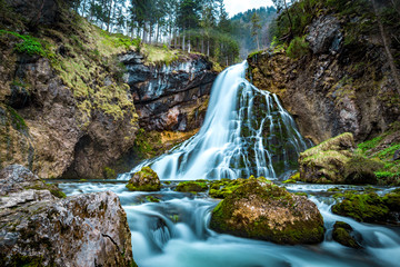 Idyllic waterfall scene with mossy rocks in the forest