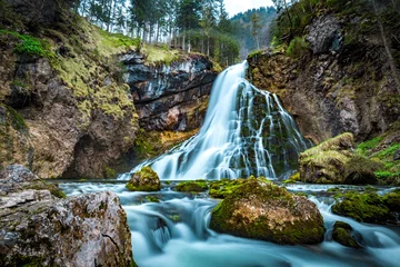 Fototapeten Idyllische Wasserfallszene mit bemoosten Felsen im Wald © JFL Photography