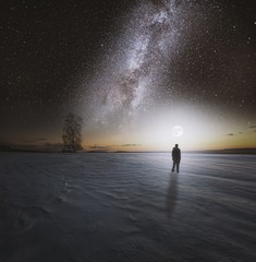 Dreamy surreal landscape with starry night sky and man silhouette. - 243586199