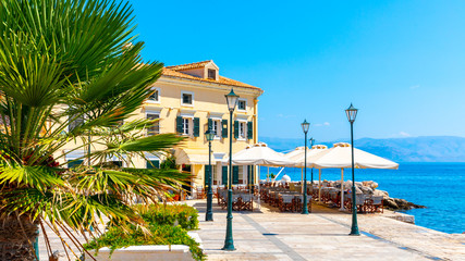Restaurant on the sea coast in the Kerkyra historic centre, Corfu town, Greece - obrazy, fototapety, plakaty