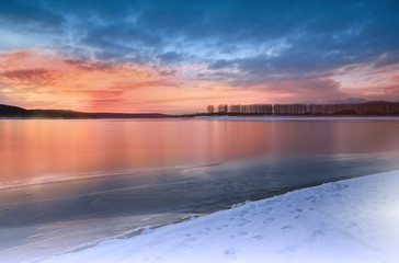 Incredibly beautiful sunset.Sun, sky,lake.Sunrise landscape, panorama of beautiful nature. Sky with amazing colorful clouds. Water reflections.Magic Artistic Wallpaper.Creative Winter Background