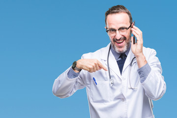 Middle age senior hoary doctor man talking on smartphone over isolated background with surprise face pointing finger to himself