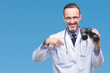 Middle age senior hoary doctor man looking through binoculars isolated background with surprise face pointing finger to himself